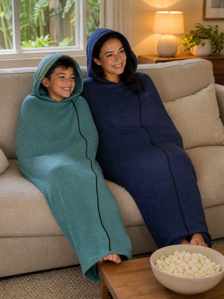Mum and son laughing on the couch in matching Snuggl Pods on movie night