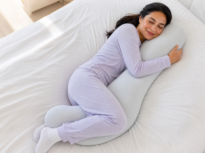 Woman side sleeping while hugging the Snuggl Body Pillow